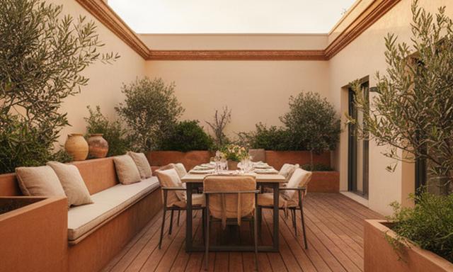 Terraza de madera tecnológica en un patio de Sevilla, con banco corrido y comedor exterior